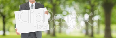 Business man holding a blank card against green blurred background