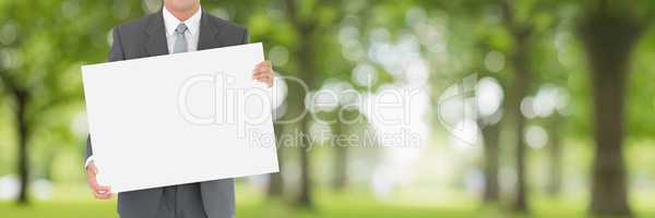 Business man holding a blank card against green blurred background