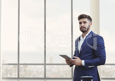 Business man holding a tablet against building background