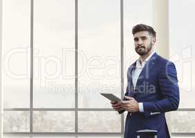 Business man holding a tablet against building background