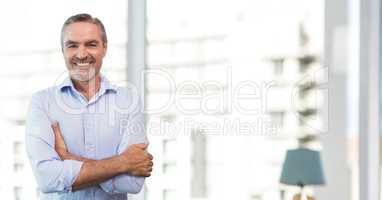 Happy business man standing against white blurred background