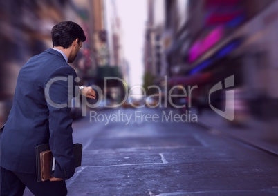 Business man looking at his clock against city background