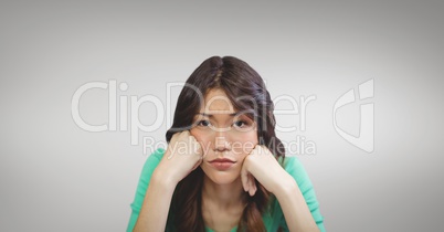 Sad business woman resting her head in her hands against grey background