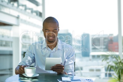 Business man having a coffee against office background