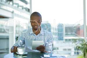 Business man having a coffee against office background