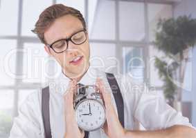 man holding clock in front of windows