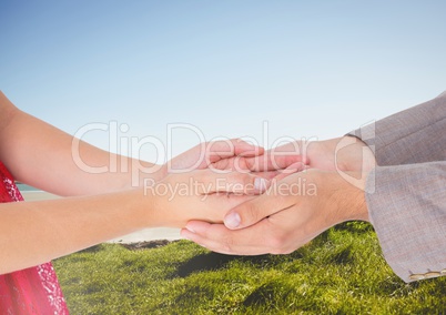 Couple's hands holding together with blue sky