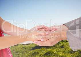 Couple's hands holding together with blue sky