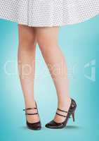 Woman's legs in skirt and high heels over blue background