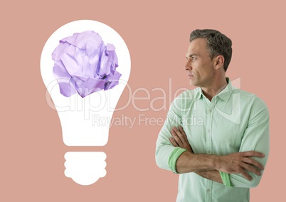 Man standing next to light bulb with crumpled paper ball