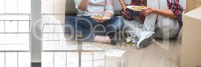 Happy couple eating pizza in their new house