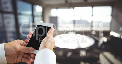 Business man using a phone against office background