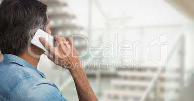Business man talking on the phone against office background