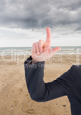 Arm pointing up at sky on beach