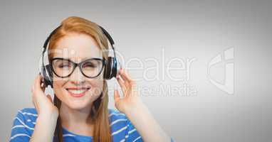 Happy business woman listening to music against grey background