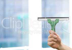 Hand holding window cleaner with blurred background