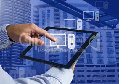 Holding tablet and Computer icons over city