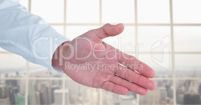 Business man stretching hand against city background