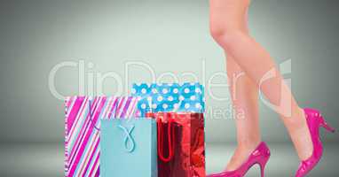 Woman's legs in high heels with shopping bags in front of vignette