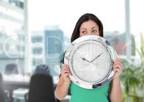 Woman holding clock in front of office