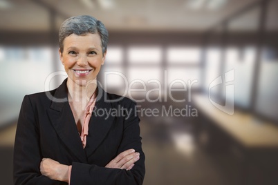 Happy business woman standing against office background