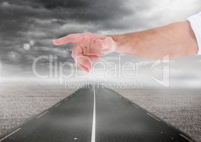 Hand pointing over road and dark clouds