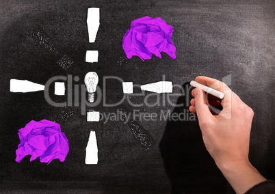 Hand drawing light bulb with crumpled paper balls in front of blackboard