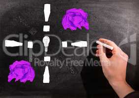 Hand drawing light bulb with crumpled paper balls in front of blackboard