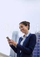 Happy business woman using a phone against city background