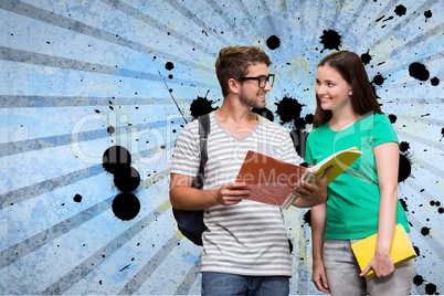Happy young students holding notebooks against blue splattered background