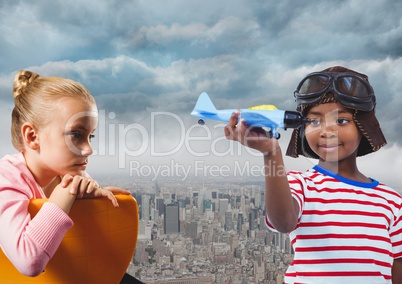 Kids with toy plane over city