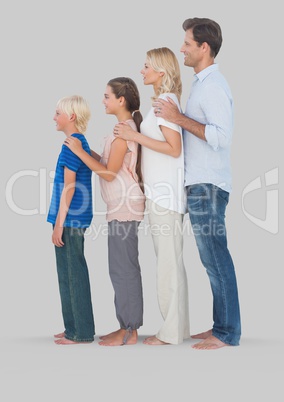 Full body portrait of family standing together with grey background