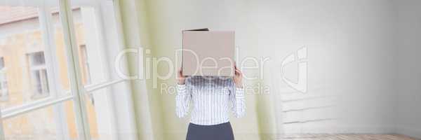 Woman with a box on her head standing in her new house