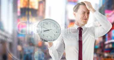 man holding clock in front of colorful city