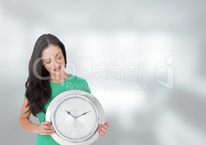 Woman holding clock in front of bright blurred background