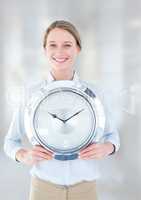 Woman holding clock in front of bright background