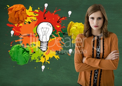 Woman standing ext to light bulb with colorful crumpled paper balls in front of blackboard