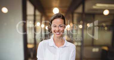 Happy business woman standing against office background