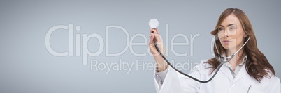 Doctor woman holding a stethoscope against grey background