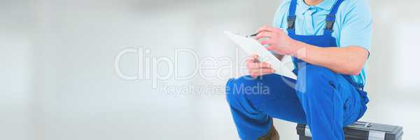 Plumber man sitting and writing against white background with flares