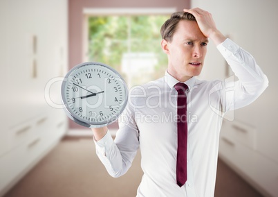man holding clock in front of room window