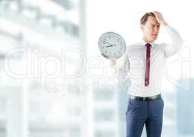 man holding clock in front of buildings