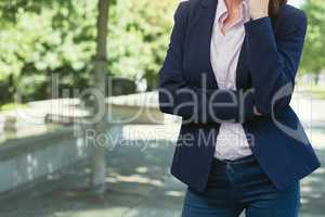 Business woman standing against park background