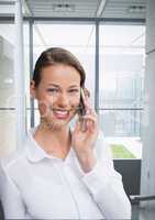 Happy business woman talking on the phone against building background