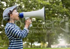 Boy with megaphone in front of trees