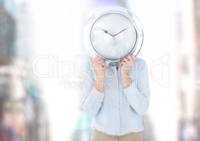 Person holding clock in front of city