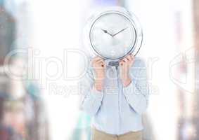 Person holding clock in front of city