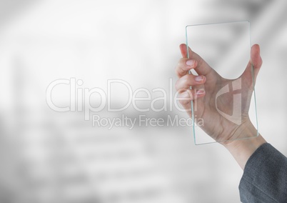Hand holding glass tablet in front of bright stairway