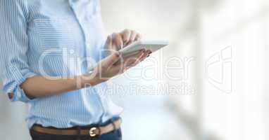 Business woman using a tablet against white blurred background