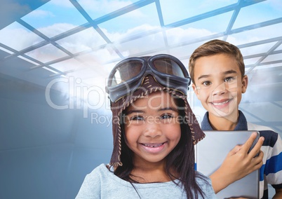 Pilot girl and boy with tablet under windows